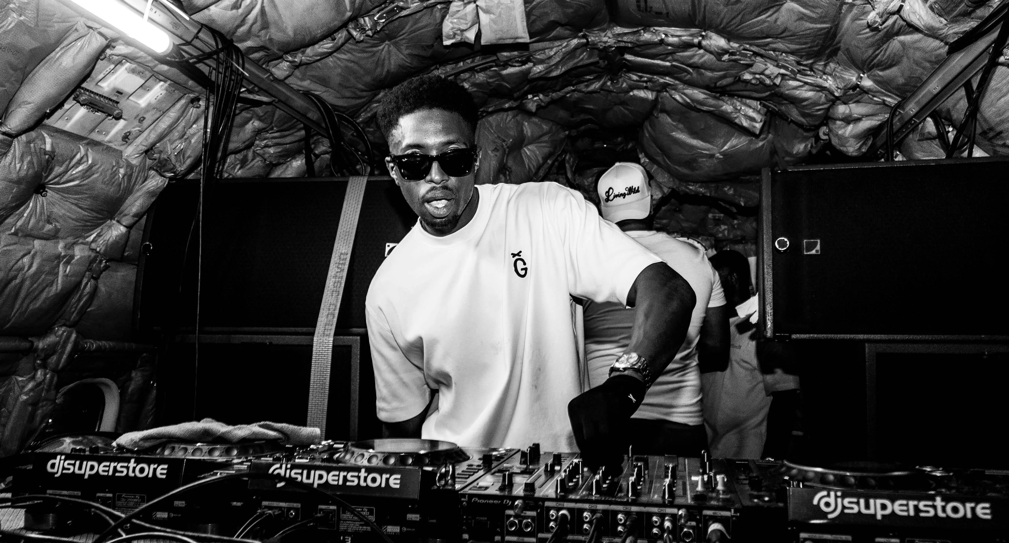 a DJ is spinning at 2 electronic CDJs, black and white